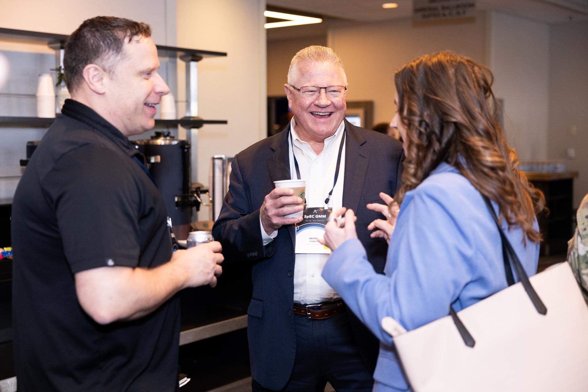 Attendees laughing and mingling at SpEC GMM
