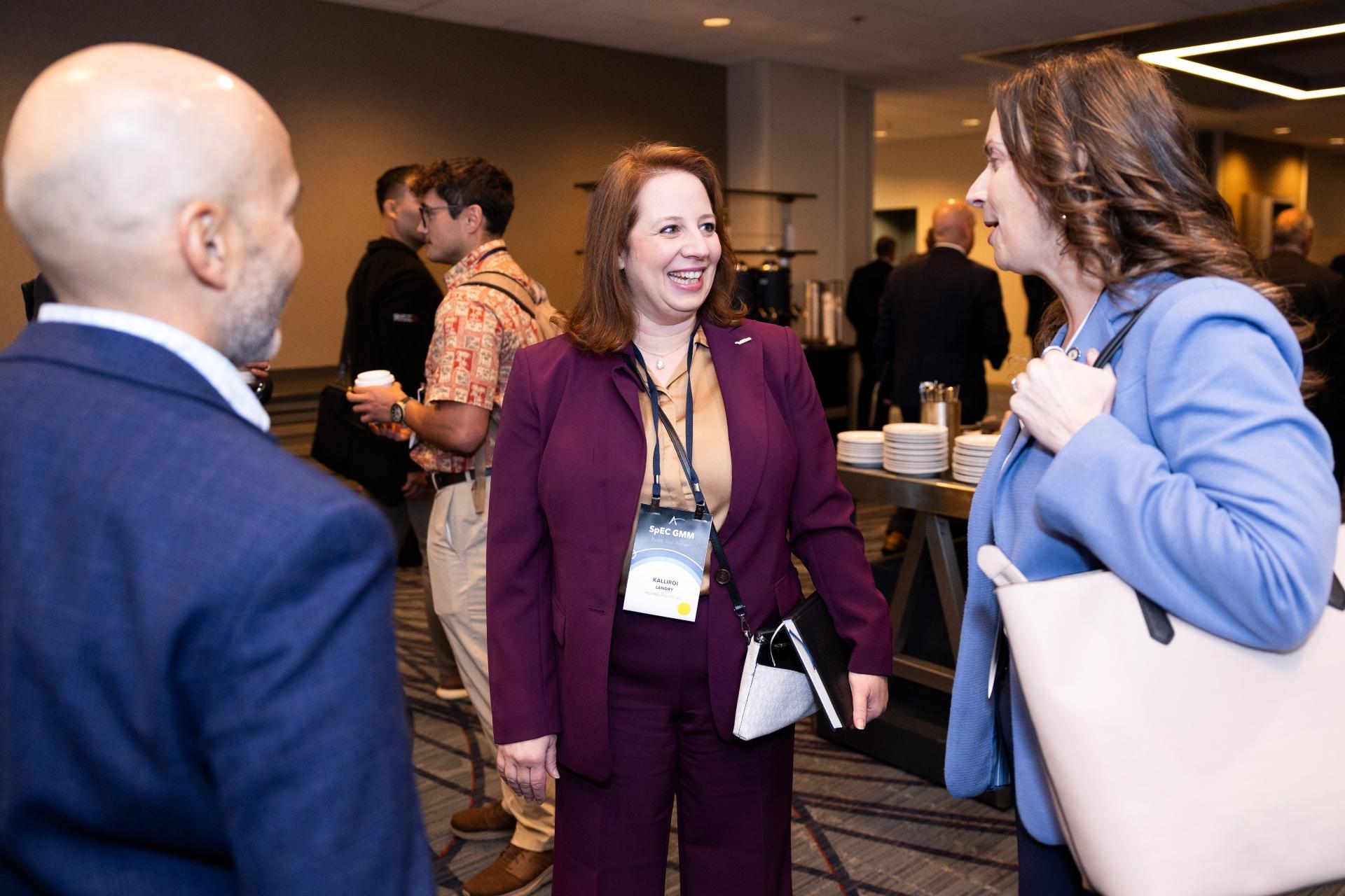 Attendees smiling and talking at SpEC GMM